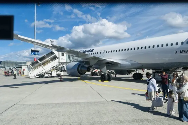 Avião parado em aeroporto em pessoas na pista