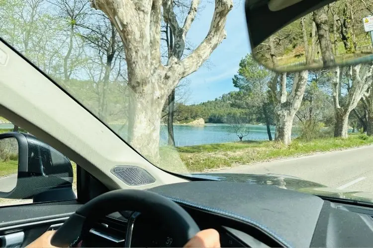 Percurso em uma viagem de carro com rio ao fundo e estrada tranquila