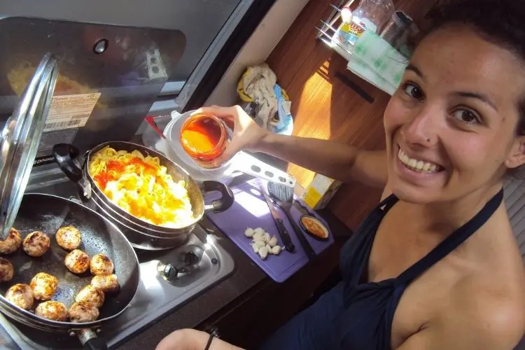 mulher preparando comida em cozinha de motorhome