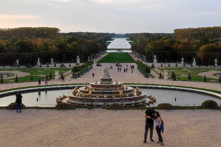 Pessoas aproveitando o jardim e parque de Versalhes.