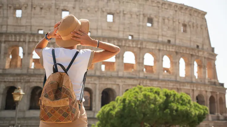 Turista em frente ao Coliseu em dia de sol na Itália.