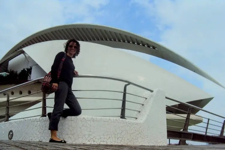 Mulher de pé, em frente a monumento branco e grande