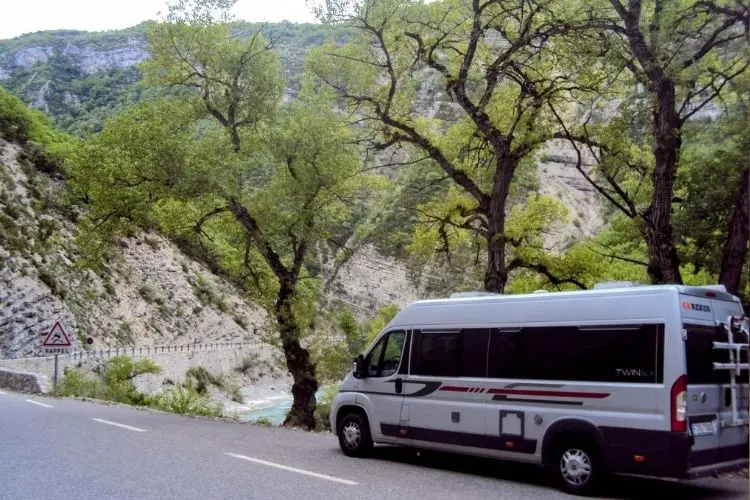 Motorhome estacionado na beira da estrada com paisagem de montanhas ao fundo