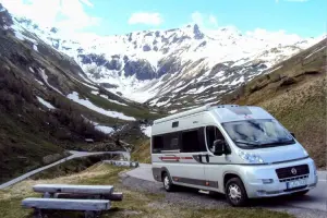 Motorhome estacionado em frente a montanha coberta de neve