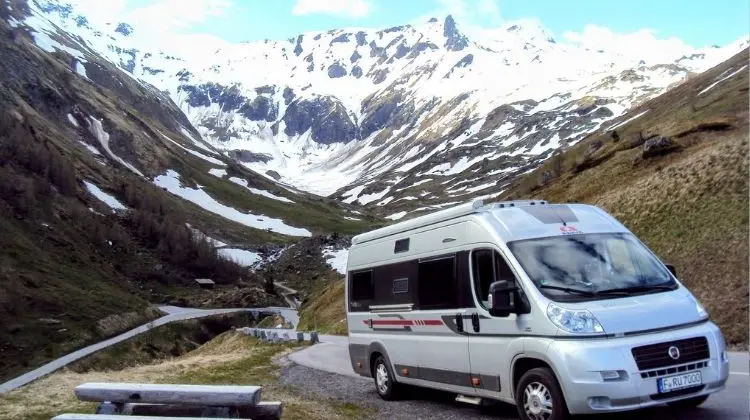 Motorhome estacionado em frente a montanha coberta de neve