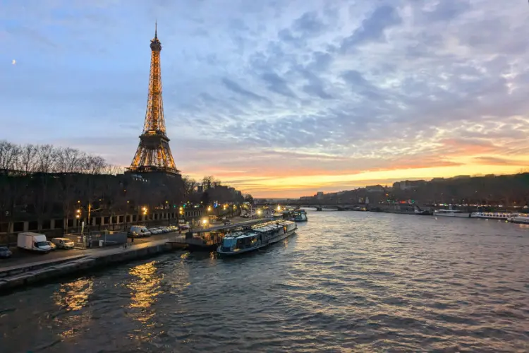 Barco com torre Eiffel ao fundo em um início de noite de inverno