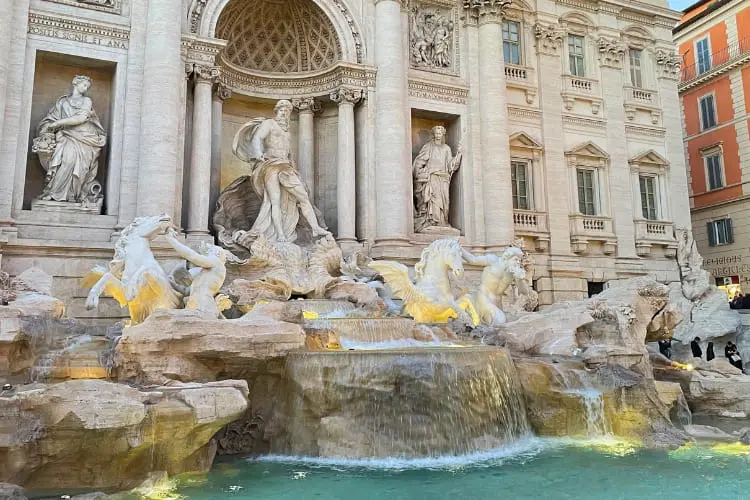 Detalhe das esculturas da Fontana di Trevi, em Roma, com cascata e estátuas iluminadas.